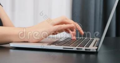 年轻女子在笔记本电脑键盘上打字的手指。 无法辨认的手在电脑键盘上打字。 关闭键盘。 商业c